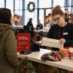 Gestion des retours de Noël en commerce : le guide A retail employee stands at a returns counter in a bustling store, surrounded by stacks of unopened gift boxes and holiday decorations, care