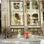 Magasins ouverts les jours fériés : règles et exceptions en un clin d’œil Vintage-style photo of a boutique storefront with bicycle and cobblestone street.