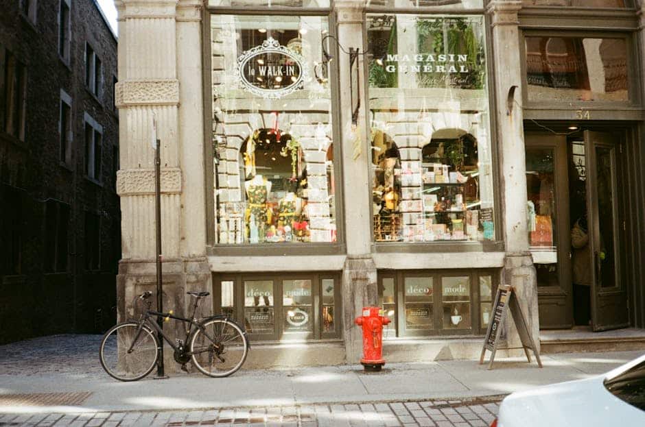 Vintage-style photo of a boutique storefront with bicycle and cobblestone street.