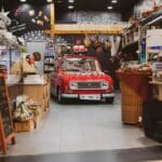 Visibilité locale de sa boutique : 7 leviers à activer pour attirer et fidéliser A vintage red car creatively displayed inside a cozy grocery store in Zagreb, Croatia.